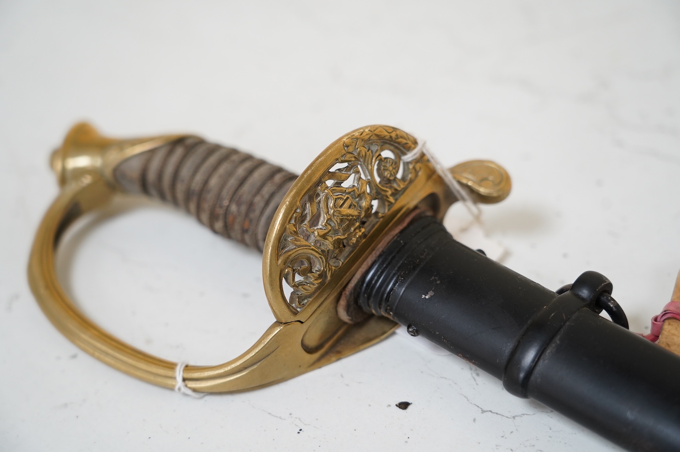 A German (Saxon) infantry officer's sword and scabbard, c.1900, with triple fullered blade, engraved with the cypher of Frederick August II, regulation brass hilt with folding side guard, in its steel scabbard, blade 80c